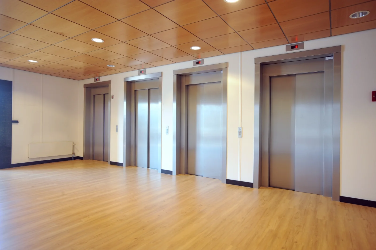 Hal met vier gesloten liften in een modern kantoorgebouw aan het Rivium Boulevard.